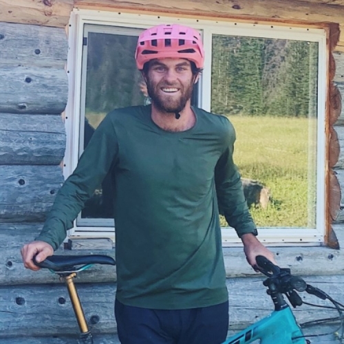 Erik Morden smiling next to a bicycle outdoors.